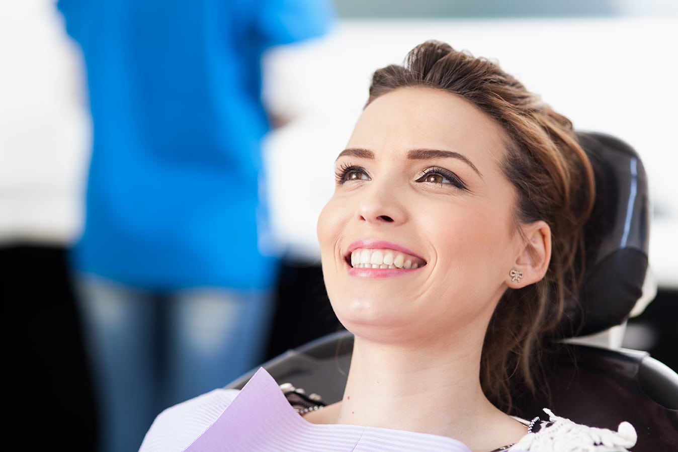Woman patient at the dentist waiting to be checked up Closeup of a woman patient at the dentist waiting to be checked up with the woman doctor in the background